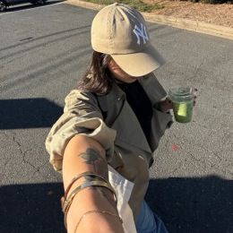 a person taking a selfie holding a matcha latte